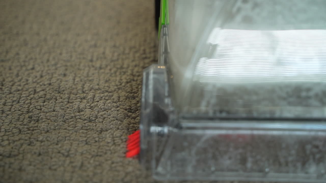 primer plano extremo de la máquina de limpieza de alfombras domésticas que aspira la suciedad y las manchas