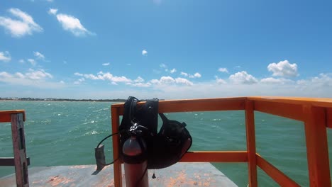 un pequeño barco turístico balanceándose contra las olas con equipo de buceo en maracajau en rio grande do norte, brasil