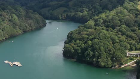 Luftaufnahme,-Die-Von-Booten-Auf-Dem-Fluss-Fowey-Nach-Oben-Gekippt-Wird,-Um-Die-Umliegende-Landschaft-Cornwalls-Zu-Enthüllen