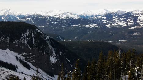 incredible reverse reveal shot of the beautiful terrain of the garibaldi provincial park in the winter, snow covered coastal mountains and evergreen forests