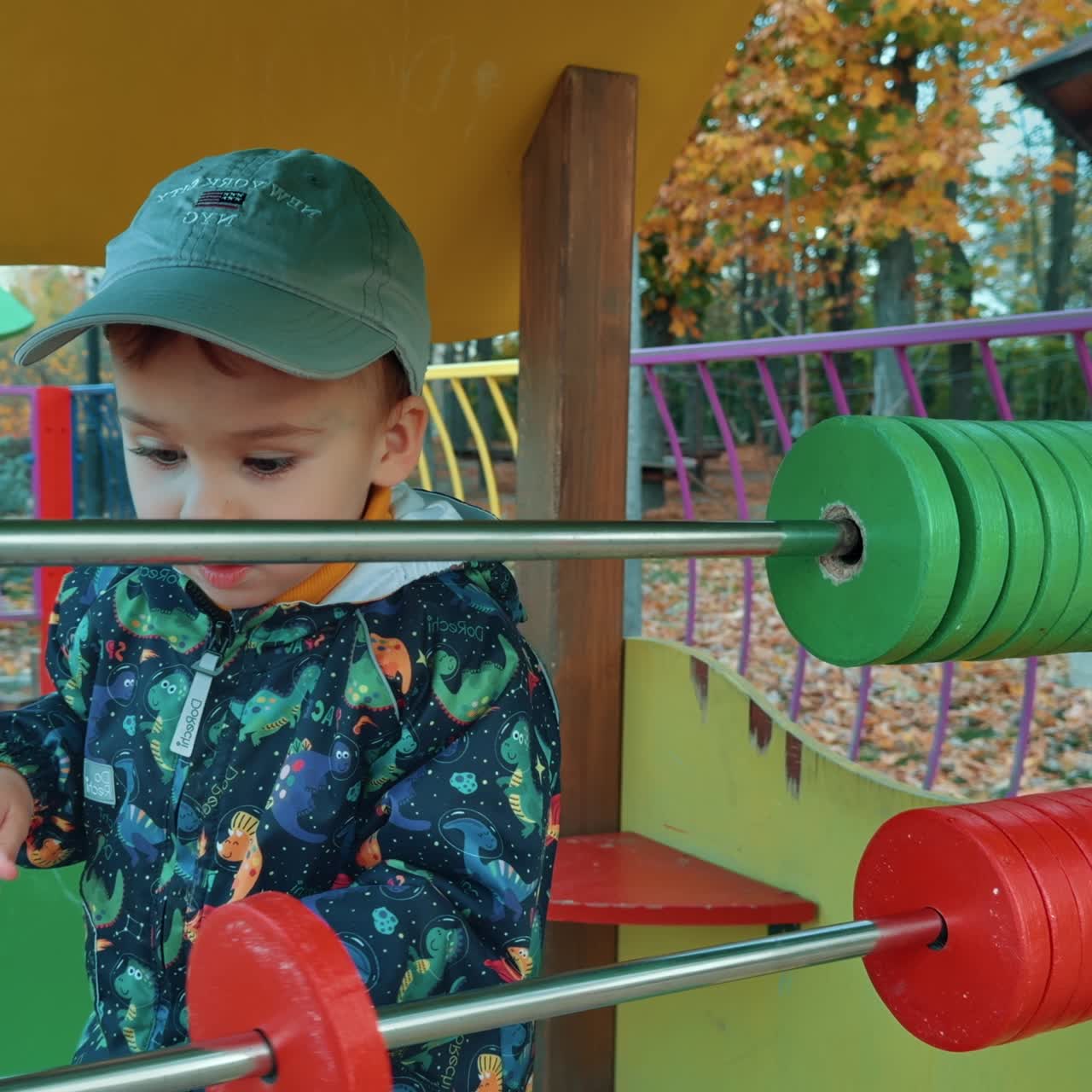 Un precioso niño caucásico jugando con un ábaco grande en el parque. Un niño pasándolo bien al aire libre en otoño.