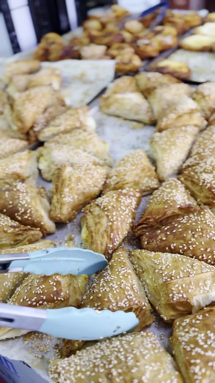 Assortment of triangular pastries with sesame seeds