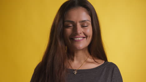 Retrato-De-Estudio-De-Cabeza-Y-Hombros-De-Una-Mujer-Sonriente-Contra-Un-Fondo-Amarillo-1