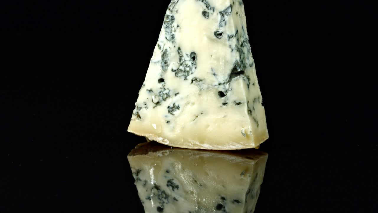 video en cámara lenta de miel de vet que se vierte de un cubo de madera, en una cuña de queso azul