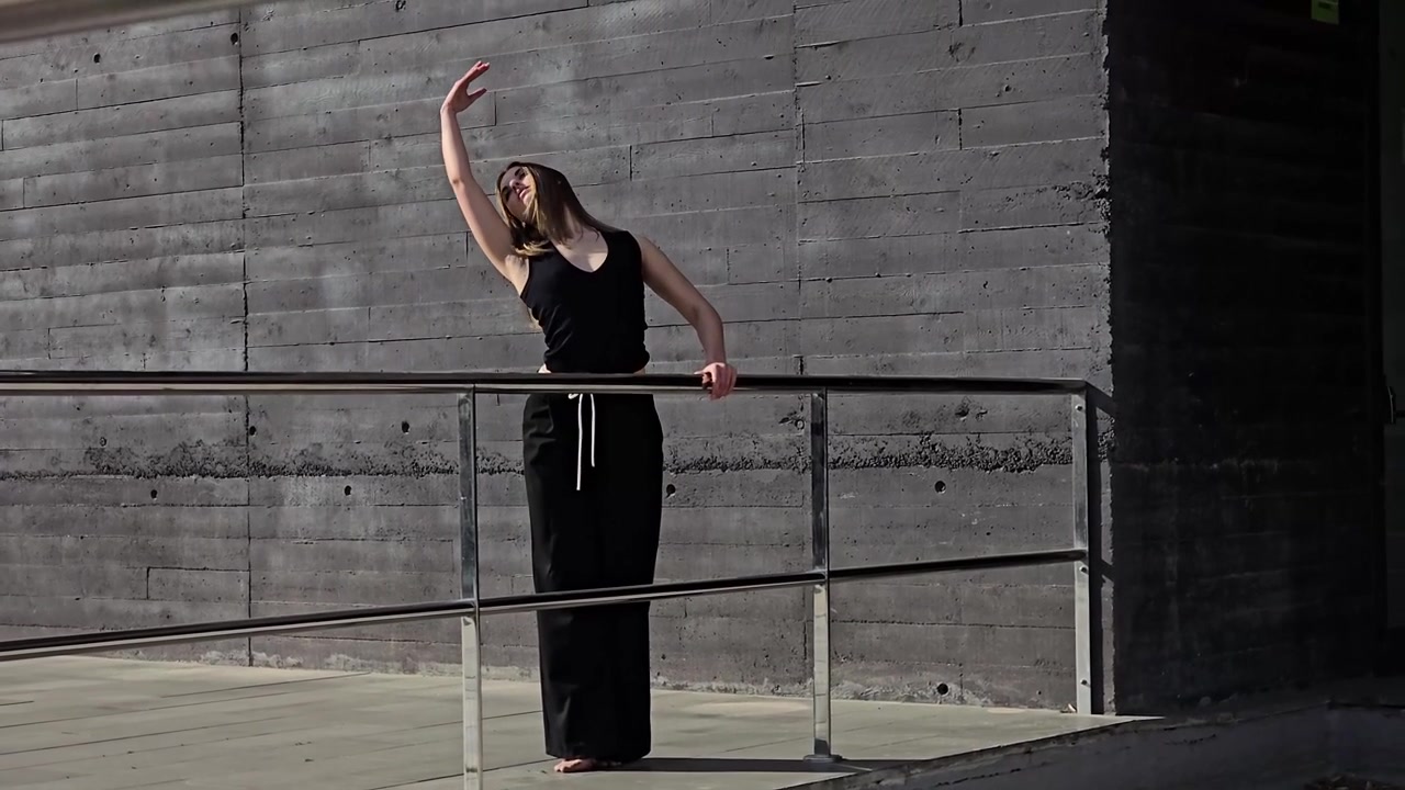 Un'accattivante performance di danza contemporanea su un balcone urbano che mette in risalto la creatività.