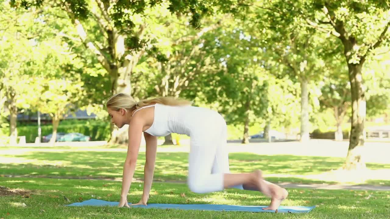hermosa rubia haciendo yoga en el parque