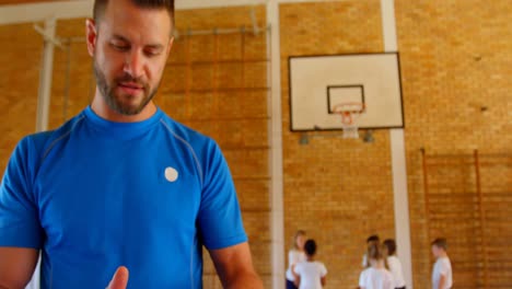 Entrenador-De-Baloncesto-Usando-Tableta-Digital-En-La-Cancha-De-Baloncesto-De-La-Escuela-4k