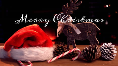 Animation-of-merry-christmas-text-over-christmas-decoration-with-santa-hat-and-reindeer