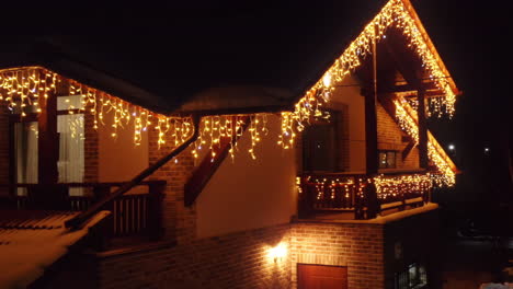 Aerial-Drone-Shot-Flying-up-to-Home-Covered-in-Christmas-Lights-at-Night