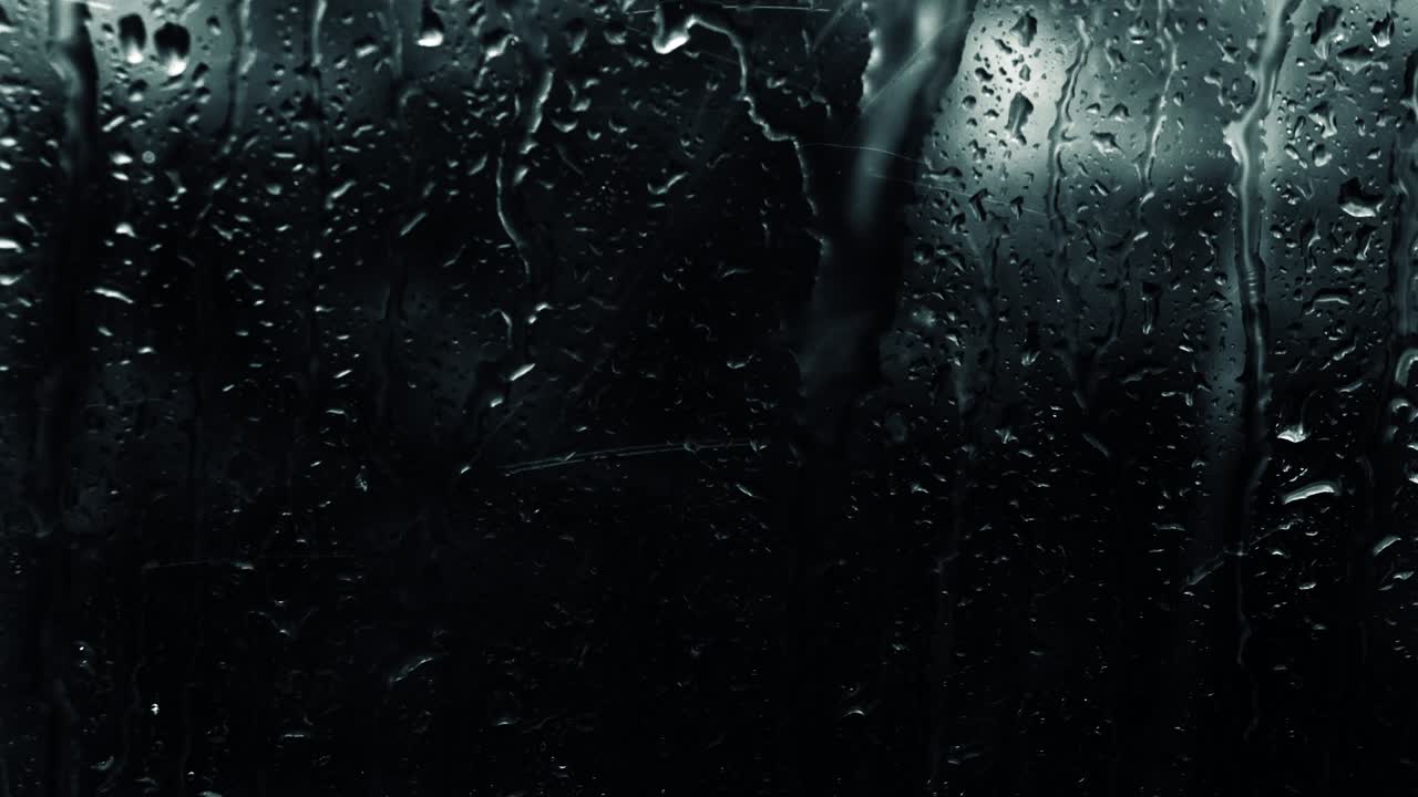 lluvia en un fondo negro enfoque suave, gotas de lluvia en el vidrio en la oscuridad