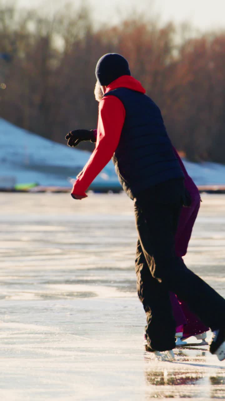 A joyful moment captured in winter as two individuals glide gracefully across a shimmering ice rink, showcasing the essence of companionship, skill, and the beauty of outdoor ice skating fun during a chilly day
