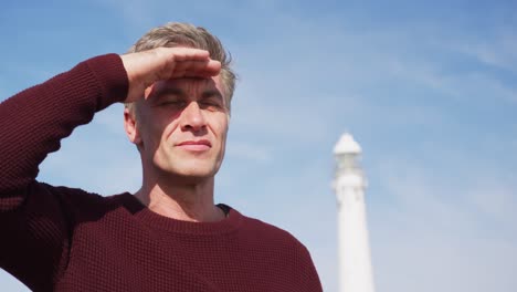 caucasian man enjoying free time by sea on sunny day looking away