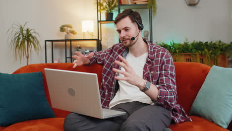 Happy-business-man-use-laptop-helpline-making-an-online-video-conference-call-in-distance-from-home