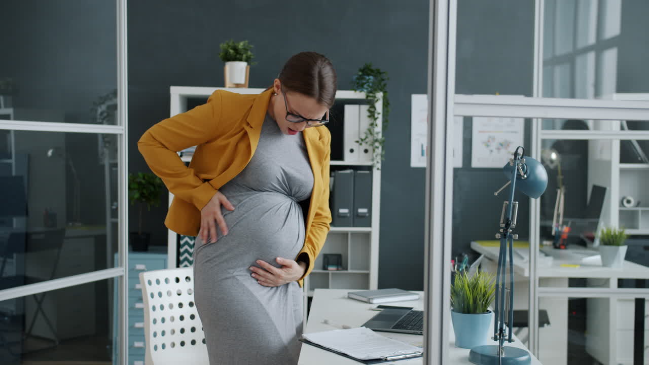 Pregnant woman experiencing pain in office