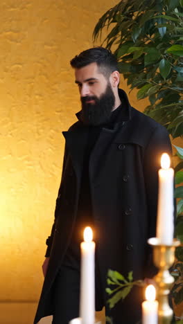 portraits of bearded men in black coats in a golden-walled room with candles