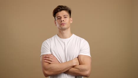 serious young man with crossed arms in white t-shirt