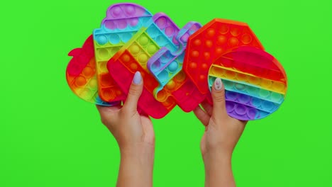 Girl-hands-showing-many-pop-it-sensory-anti-stress-bubbles-squish-toys-game-isolated-on-chroma-key