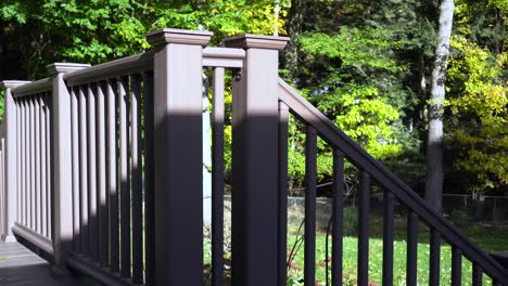 Still-take-of-a-plastic-fence-on-a-deck,-the-high-sun-shining-through-on-a-warm-day