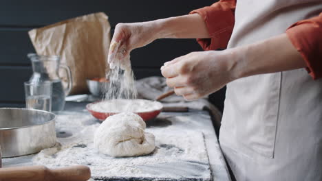 hands of woman kneading dough in bakery