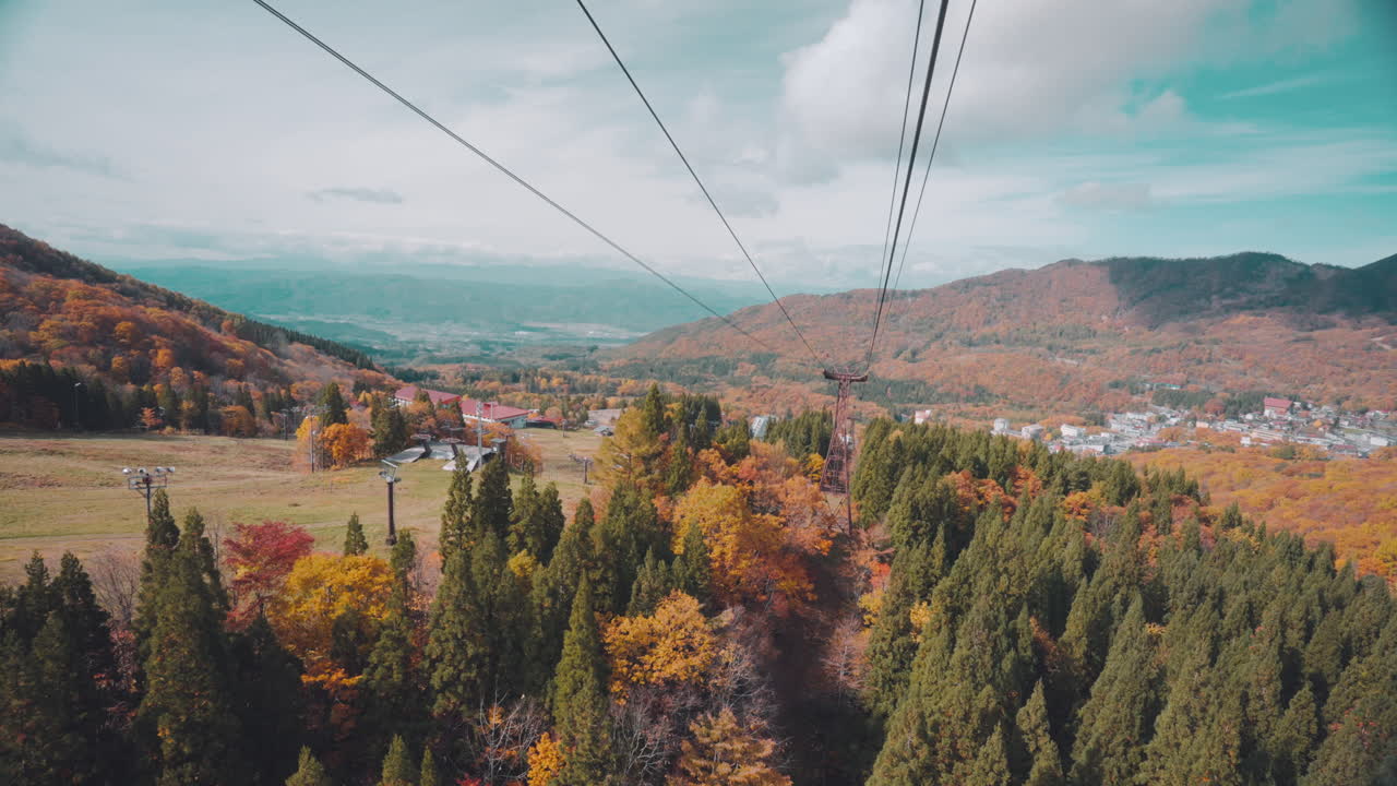 pov de una persona que viaja en teleférico subiendo en zao con árboles de otoño y vistas a la montaña en japón