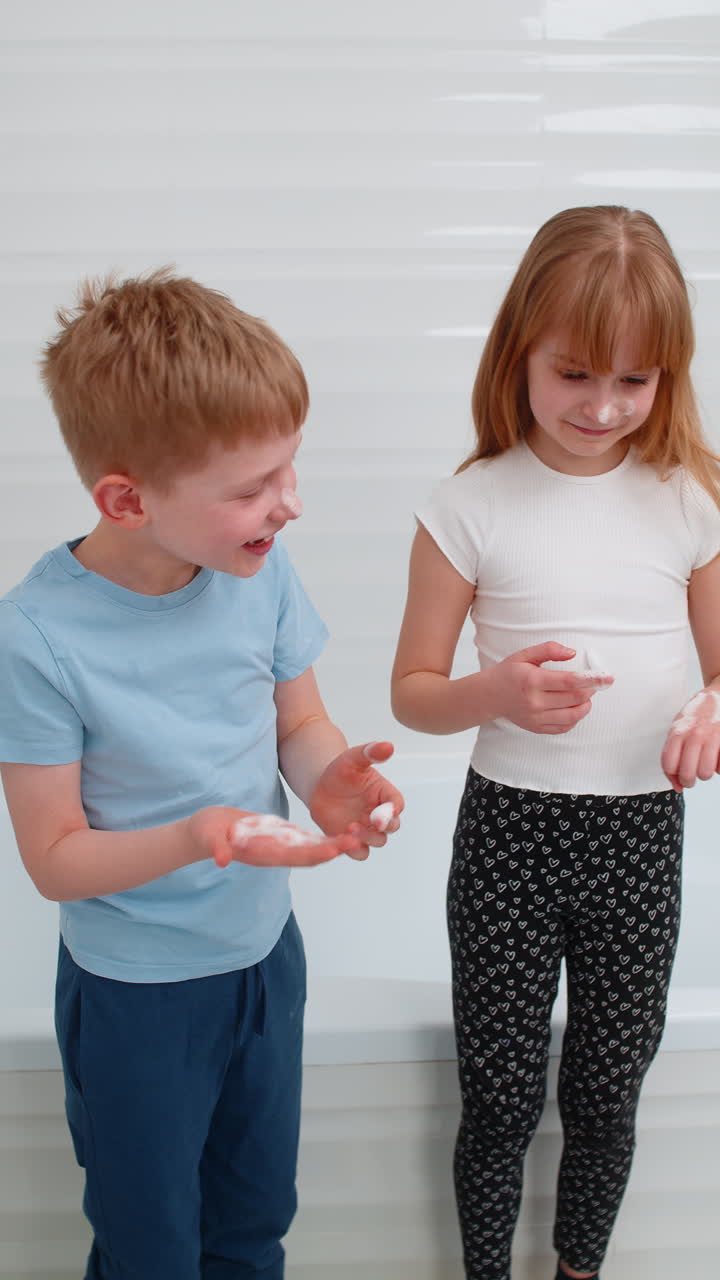 Kids applying face foam in bathroom laughing and playing while doing morning skincare with energy