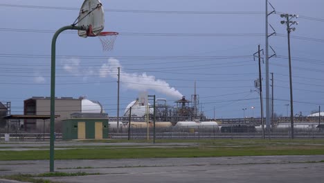 Una-Cancha-De-Baloncesto-Vacía-Se-Encuentra-Frente-A-Una-Gran-Refinería-De-Petróleo