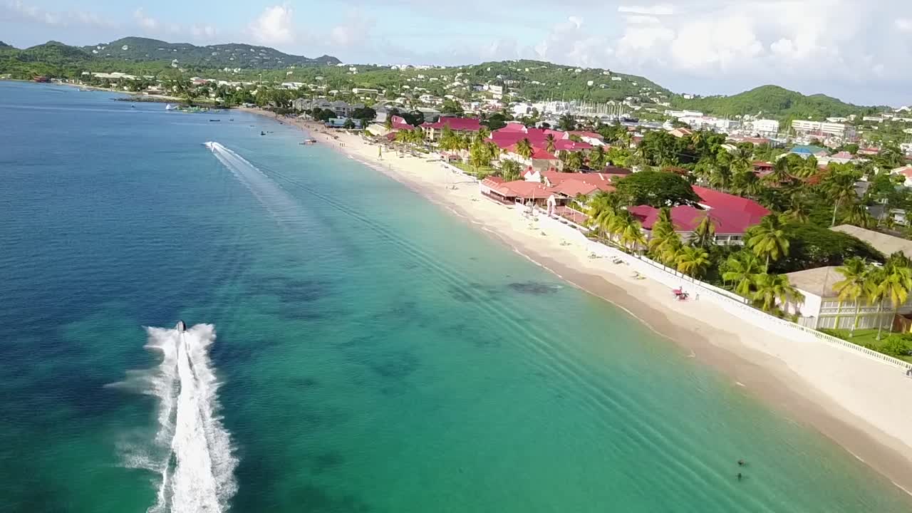 Ripresa aerea di una moto d'acqua che sfreccia sulla spiaggia di Reduit a Santa Lucia