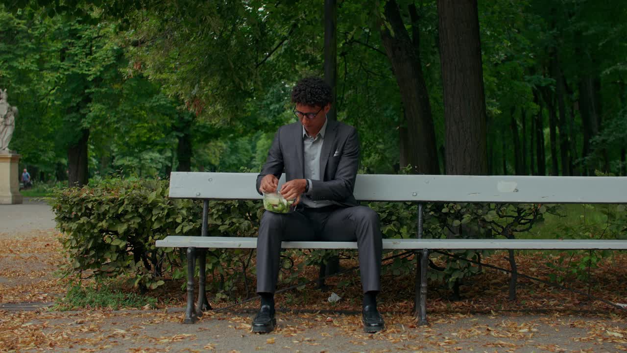 Uomo che mangia insalata al parco