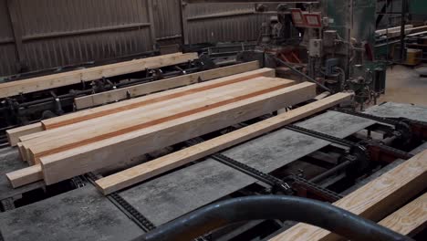 inside view of a modern sawmill where trees get cut into lumber, pan left