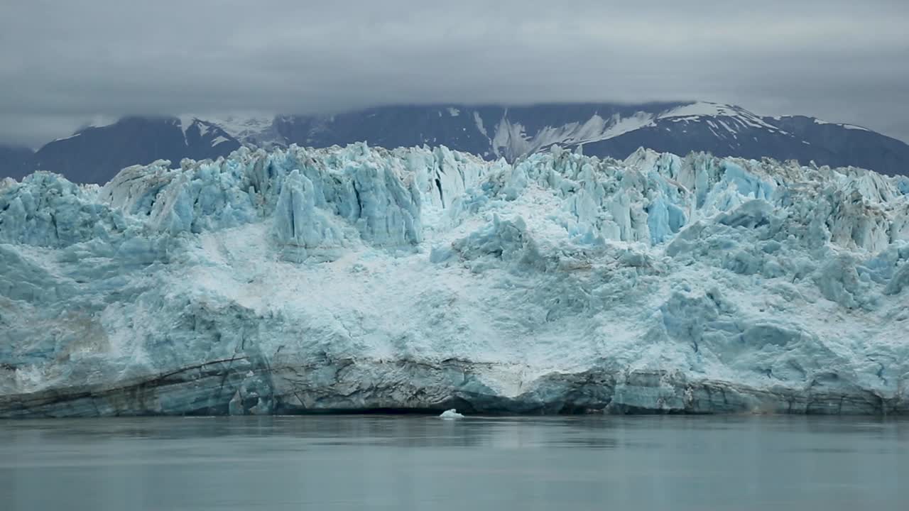 toma panorámica del enorme glaciar hubbard en alaska, ee.uu. en un día nublado oscuro, frío y sombrío con enormes montañas cubiertas de nieve en el fondo