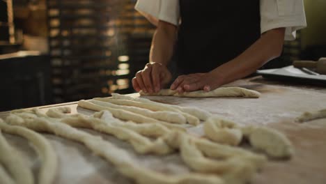 animation of hands of african american male baker rolling sourdough at bakery