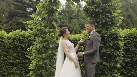 Newlyweds,-caucasian-groom-with-bride-walking,-embracing,-hugs-in-park,-wedding-couple