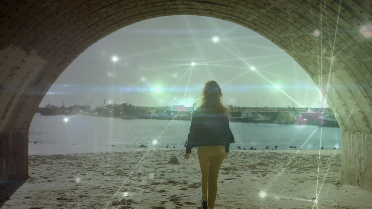 Walking under bridge towards beach, person with digital animation overlay