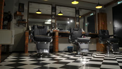 vintage hanging lamps in hairdressing salon. ceiling retro lamp in barber shop. barber pole. hair salon interior. metal ceiling lights in barbershop