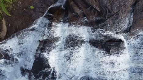 Lateral-camera-movement-with-drone-filming-a-beautiful-waterfall-very-close,-flowing-waters