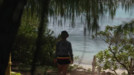 girl walking towards the beach area in a tropical island, slow motion