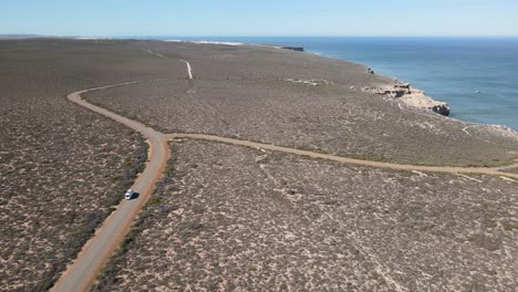 Avión-Teledirigido-Sobre-Una-Autocaravana-En-Un-Largo-Camino-Junto-A-Un-Hermoso-Océano