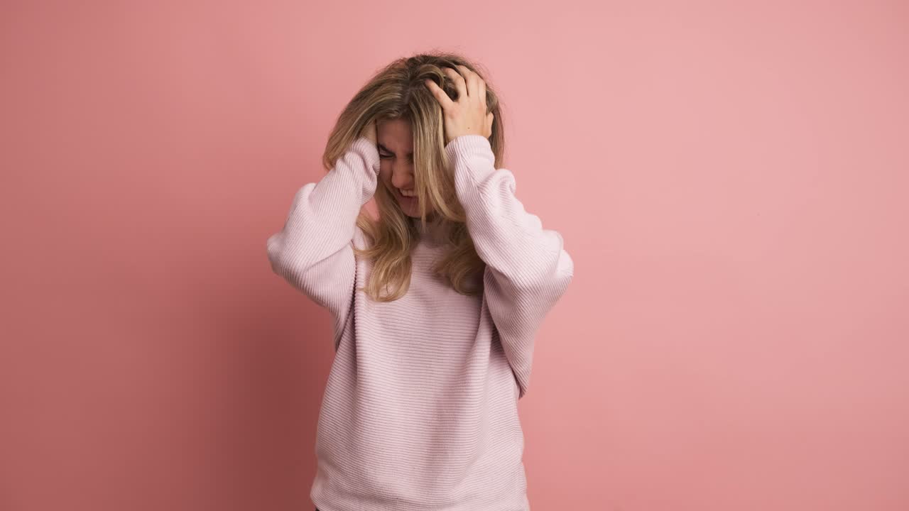 Woman gesturing headache hands on head