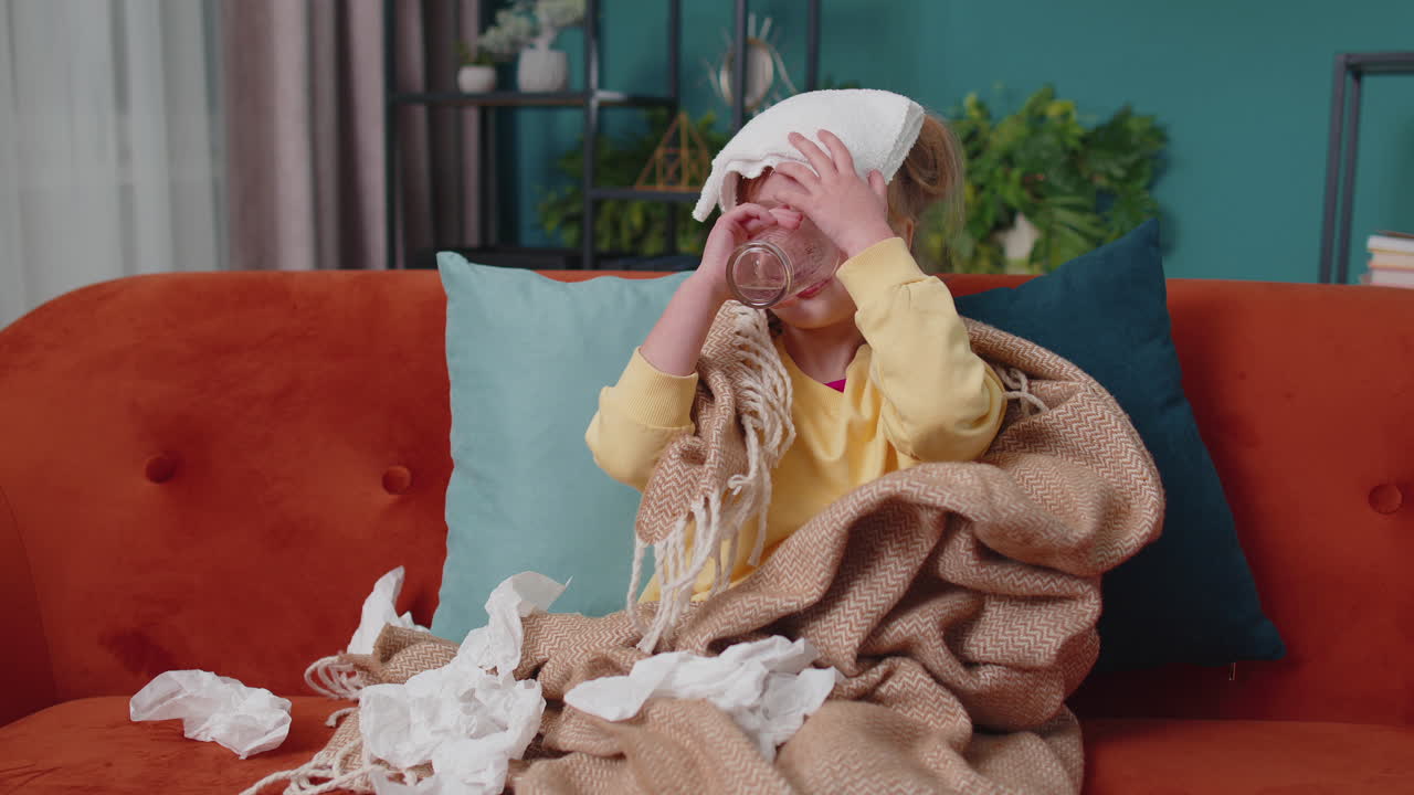 Child girl in plaid suffering from cold or allergy, drinking medicine pill tablet water at home room