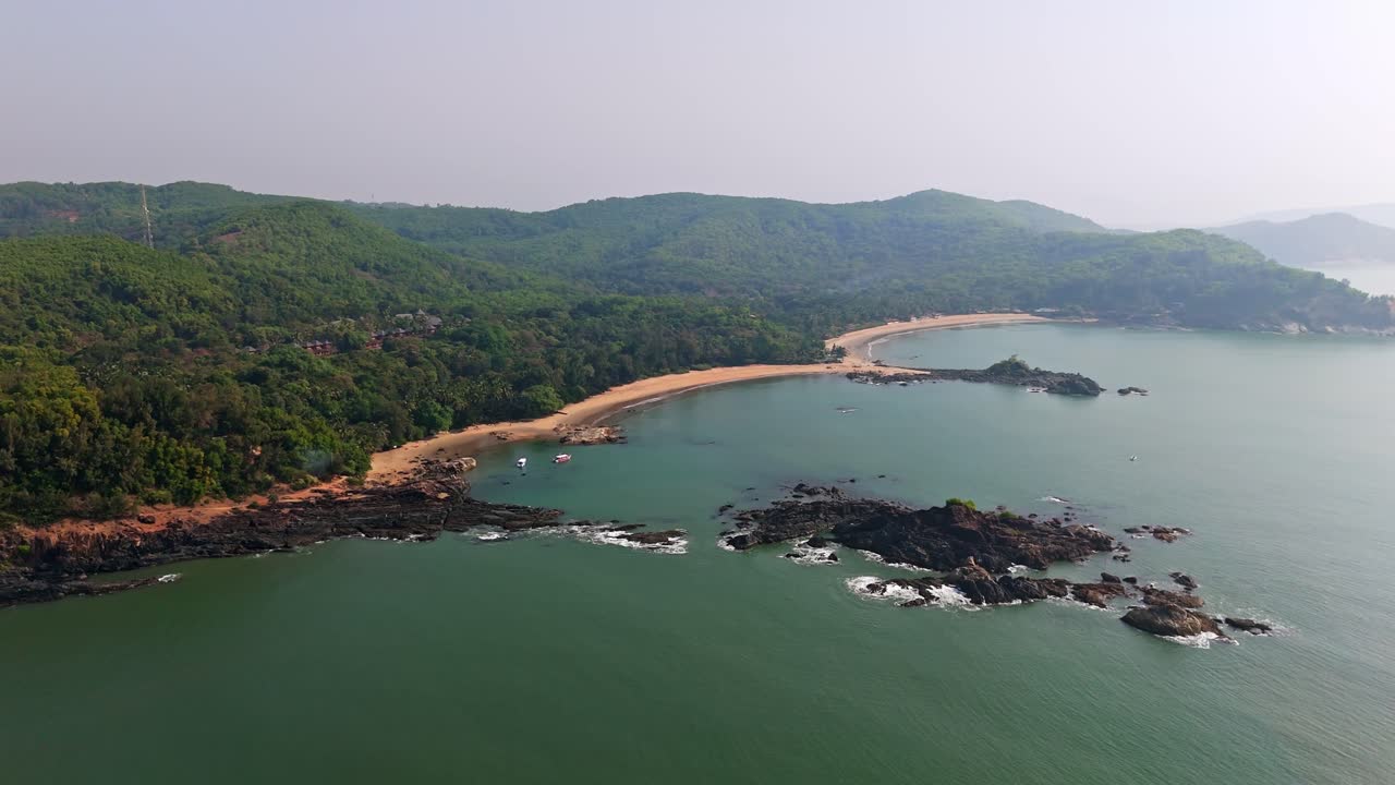 Aerial view rotating away from the Om beach, hazy morning in Gokarna, India