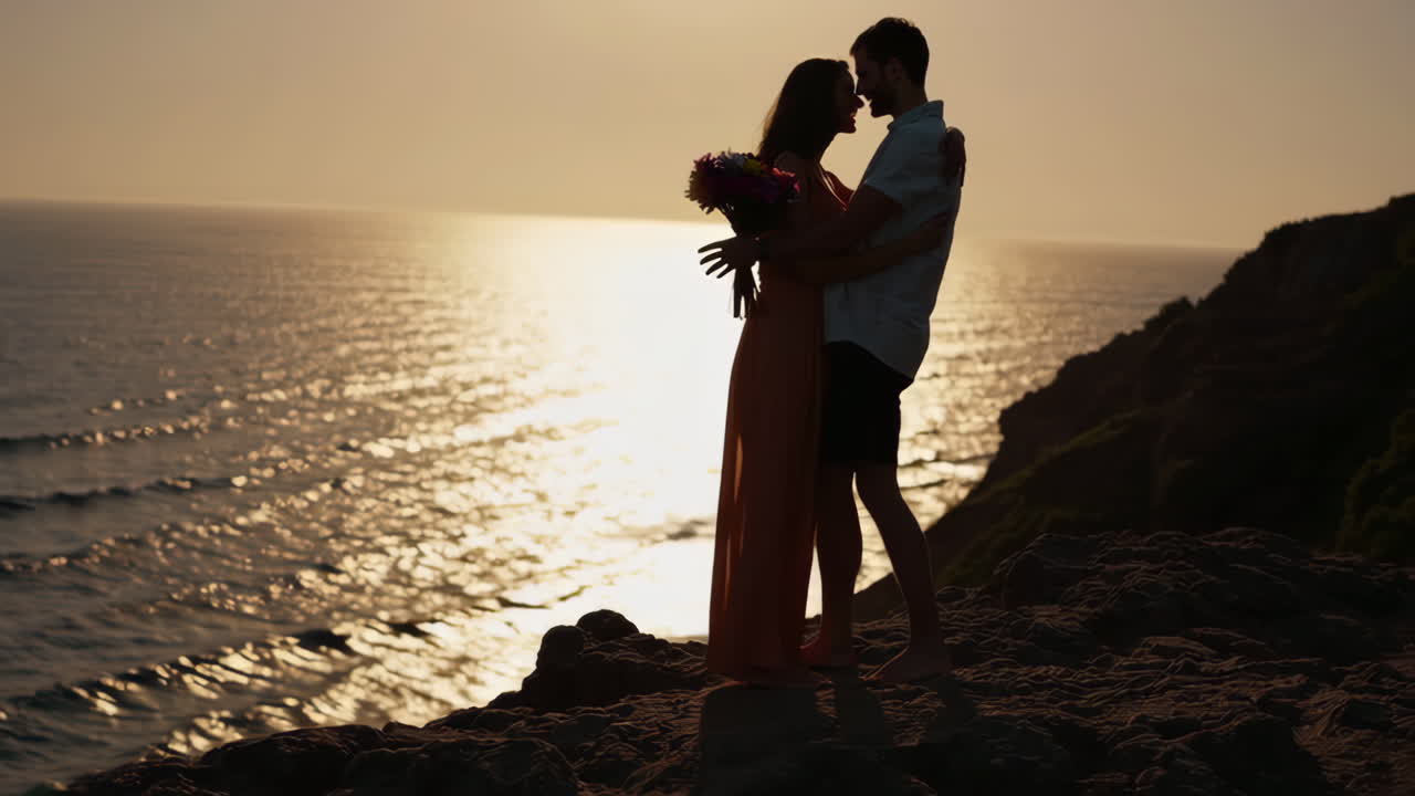 Couple embracing on a cliff at sunset