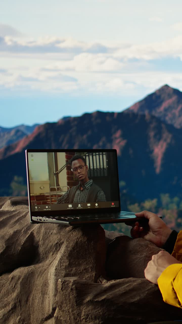 Man on Video Call with Laptop in Scenic Mountains