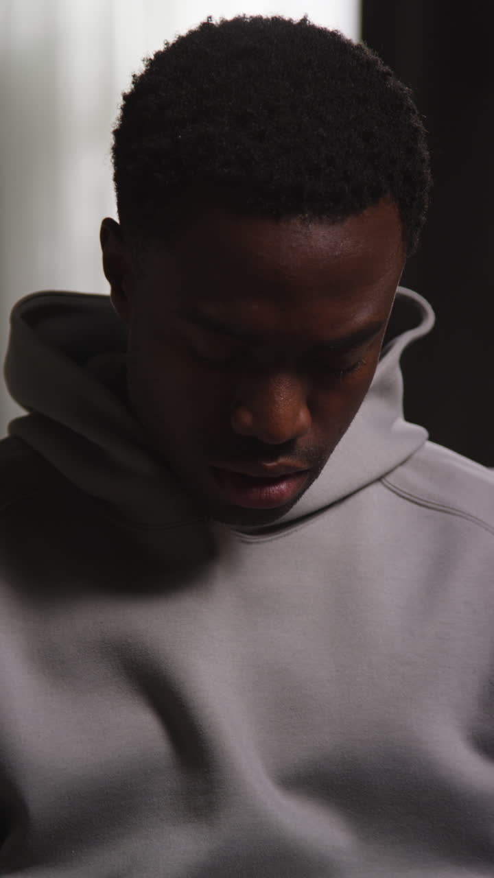 Vertical Video Of Unhappy And Depressed Young Man Sitting On Sofa At Home Looking Anxious And Worried Closing Eyes And Shaking Head 1