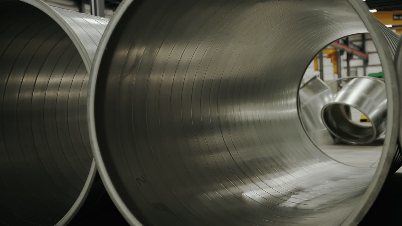 Tubazioni di riscaldamento e raffreddamento HVAC appoggiate a terra in un magazzino.