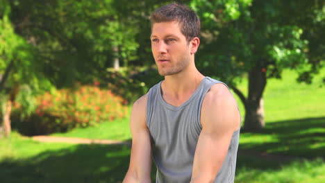 Handsome-man-using-dumbbells-outdoors