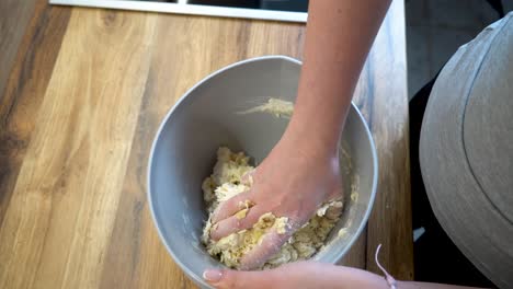 woman mixing ingredients of pasta in a bowl