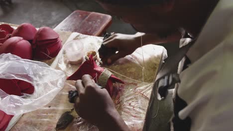 mixed race man stitching equipment in factory