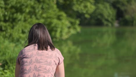 back of female enjoying sunny summer day in greenery of central park, new york