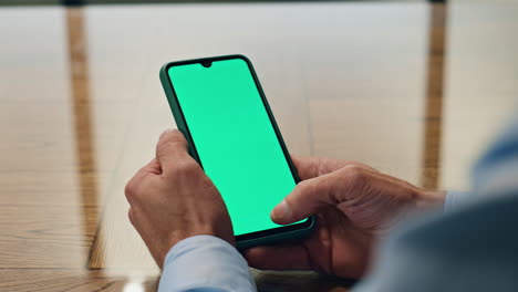 Mann-Mit-Der-Hand-Scrollt-Durch-Greenscreen-Smartphone-Im-Innenbereich,-Nahaufnahme.-Manager-Hält-Telefon