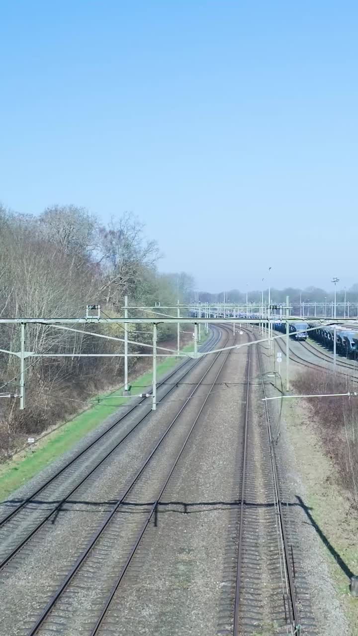 Multiple Train Tracks with a Distant Train Under a Clear Blue Sky